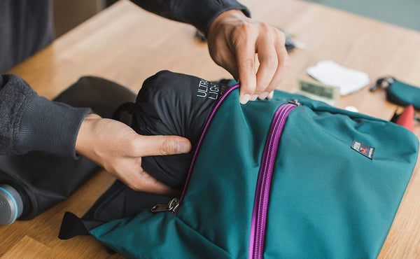 A person putting a stuff sack in the main compartment of the Icon.